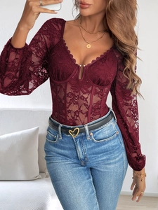 Gros plan du body en dentelle bordeaux avec décolleté en V et détails de corset