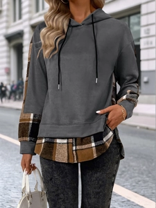 Détail du sweat à capuche gris avec empiècements à carreaux pour un effet superposé