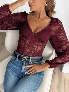 Détail d'un body en dentelle bordeaux avec encolure bustier et manches longues transparentes