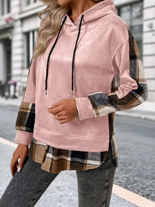 Détail d'un sweat à capuche rose en velours avec patchwork à carreaux écossais