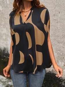 Detail view of v-neck short sleeve shirt with bold geometric print in brown and black tones