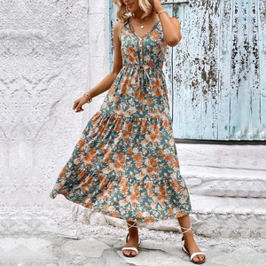 Détail d'une robe longue bohème fleurie avec col en V et jupe à volants vert sauge