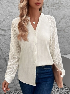 Detail der weißen Spitzen-Patchwork-Bluse mit strukturiertem Stoff und Knöpfen