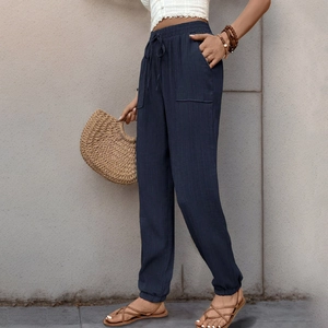 Dettaglio dei pantaloni blu navy con trama in rilievo, coulisse in vita e tasche esterne
