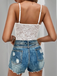 Detailed back view of white floral lace camisole paired with distressed blue denim shorts