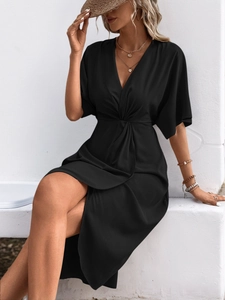 Close-up of the elegant black V-neck dress featuring a stylish waist knot and draped fabric