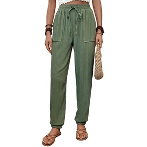 Dettaglio dei pantaloni joggers verdi con vita elastica a coulisse e ampie tasche frontali