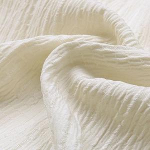 Nahaufnahme der beigen Langarmbluse mit geraffter Textur und Spitzen-Details