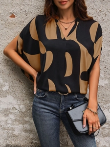 Detail of V-neck loose shirt with geometric print styled with jeans and handbag