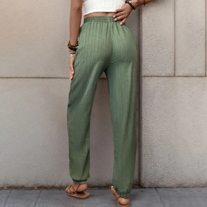 Dettaglio dei pantaloni jogger verde militare in tessuto a trama verticale e vita alta elastica
