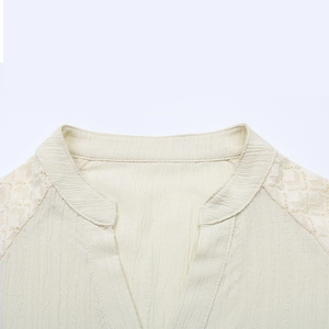 Detailansicht der cremefarbenen Strukturbluse mit Spitzenbesatz und elegantem Stehkragen