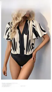 Detail of the elegant deep V-neck and ruffled sleeves on the geometric print bodysuit
