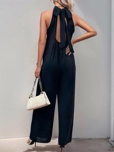 Dettaglio elegante tuta halter con schiena scoperta e grande fiocco decorativo sul retro