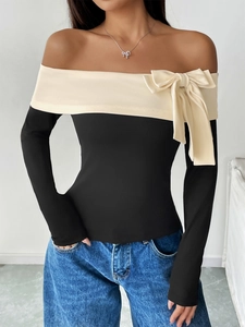 Detail of off-shoulder neckline with a delicate bow on a black and white long sleeve top
