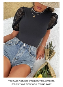 Close-up of black short sleeve bodysuit with mesh puff sleeves on beach background