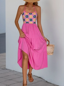 Detail of vibrant rose pink halter dress with colorful bohemian crochet chest panel