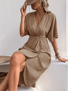 Detail of a khaki satin dress featuring a deep V-neck and elegant waist twist knot detail