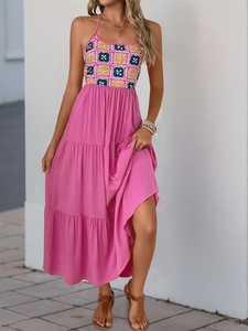 Detail of bohemian halter neck dress featuring colorful crochet top and pink tiered skirt