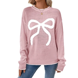 Pink long-sleeve knit sweater with a white bow pattern and decorative stitching details