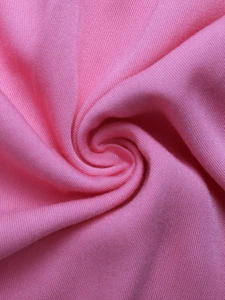 Detailed close-up of pink knit fabric texture with fine ribbed patterns and soft finish