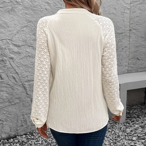 Elegante cremefarbene Langarmbluse mit strukturierter Textur und aufwendigen Spitze-Patchwork-Ärmeln