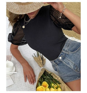 Detail of elegant black ribbed bodysuit with textured mesh puff sleeves and round neck