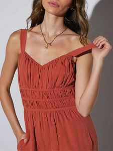Detail of rust red smocked pleats and wide straps on a summer women jumpsuit