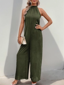 Dettaglio della tuta verde scuro con scollo all'americana e gamba larga in tessuto leggero
