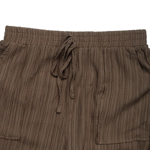 Dettaglio dei pantaloni casual marrone caffè testurizzati con vita elastica e coulisse