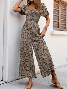 Detailed view of smocked square neckline and puff sleeves on floral wide-leg jumpsuit