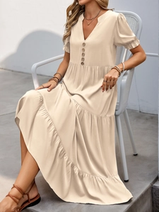 Detail of apricot v-neck maxi dress with puff sleeves and button-down tiered skirt