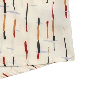Detail of color block vertical striped print on cream-colored blouse with fine stitching