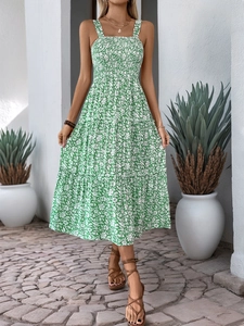 Detail of smocked bodice and tiered ruffle hem on a green floral midi dress