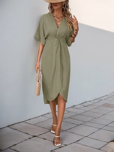 Detail of olive green dress featuring waist knot pleats and an asymmetrical crossover hem