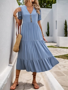 Detail of blue V-neck tiered dress with wooden buttons and pleated cuffs for summer