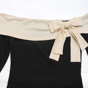 Detail of off-the-shoulder neckline with contrast trim and elegant bow accent