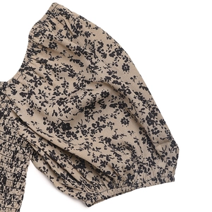 Detail of floral puff sleeves and elastic smocking texture on summer jumpsuit