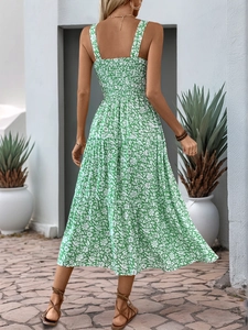 Detail of the green floral maxi dress featuring a smocked back and tiered skirt design