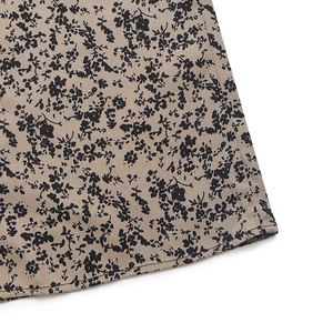 Detailed view of beige floral print fabric texture and hem stitching on summer jumpsuit