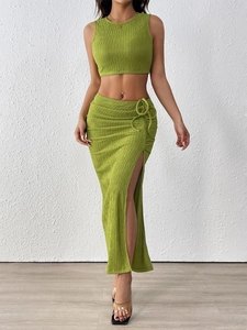 Dettaglio del tessuto a costine verde con trama increspata e coulisse sulla gonna