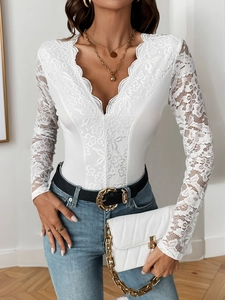Detailed view of white floral lace embroidery on a deep V-neck long sleeve bodysuit