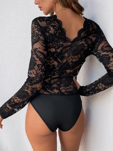 Detail eines schwarzen Spitzen-Bodysuits mit tiefem V-Rückenausschnitt und Blumenmuster