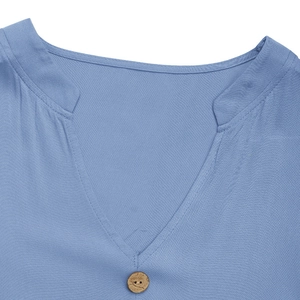 Detail of light blue cotton linen shirt showing stand collar, V-neck, and wood button texture