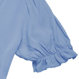 Detail of light blue dress showing textured fabric, puff sleeves and ruffled cuffs
