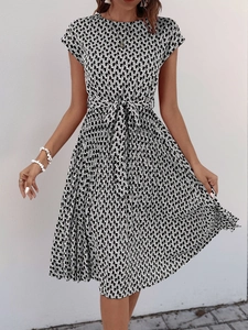 Close-up of geometric wave print texture and waist tie detail on short sleeve dress