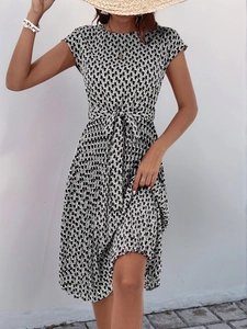 Detail of short sleeve dress with geometric print and waist tie-belt shown on model