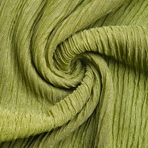 Dettaglio macro della trama del tessuto plissettato verde oliva con motivi sofisticati