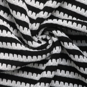 Macro detail of black and white striped knit fabric with zigzag textured weaving
