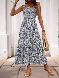 Detail of smocked bodice and floral print on a white summer tiered maxi dress