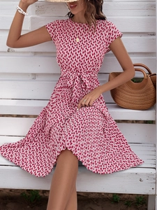 Detail of red and white geometric print summer dress with pleated skirt and waist tie belt